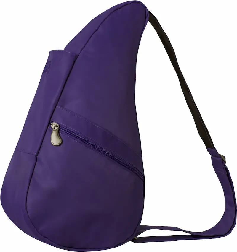 Purple teardrop shaped sling backpack with a single black shoulder strap and a curved zippered front pocket. The asymmetrical design is contoured to sit close against the back.