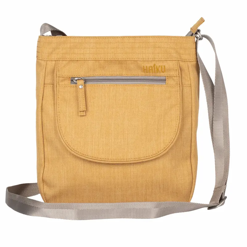 Mustard yellow crossbody bag with a gray adjustable shoulder strap and a large rounded front pocket. A horizontal zippered pocket sits above the front pouch, with subtle stitched detailing across the top.