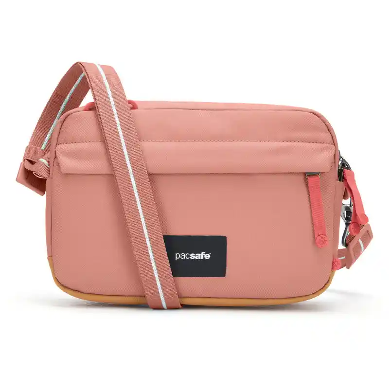 Pink Pacsafe crossbody bag with a wide adjustable shoulder strap and a rectangular zippered design. The front has a small vertical zipper pocket and black Pacsafe logo patch.