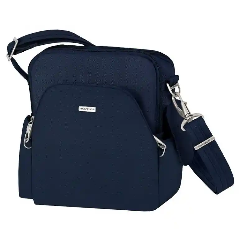 Navy blue crossbody travel bag with an adjustable padded shoulder strap and silver hardware. The compact rectangular design has multiple zippered compartments including a large curved front pocket.